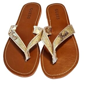 Size 7 NWOT gold sparkle guess flip flops. Super comfortable